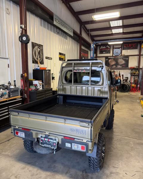 Rear view of a compact pickup with a utility bed and off-road tires
