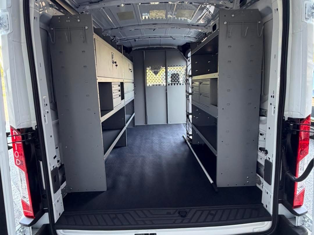 Full commercial van interior with shelving on both sides and a partition